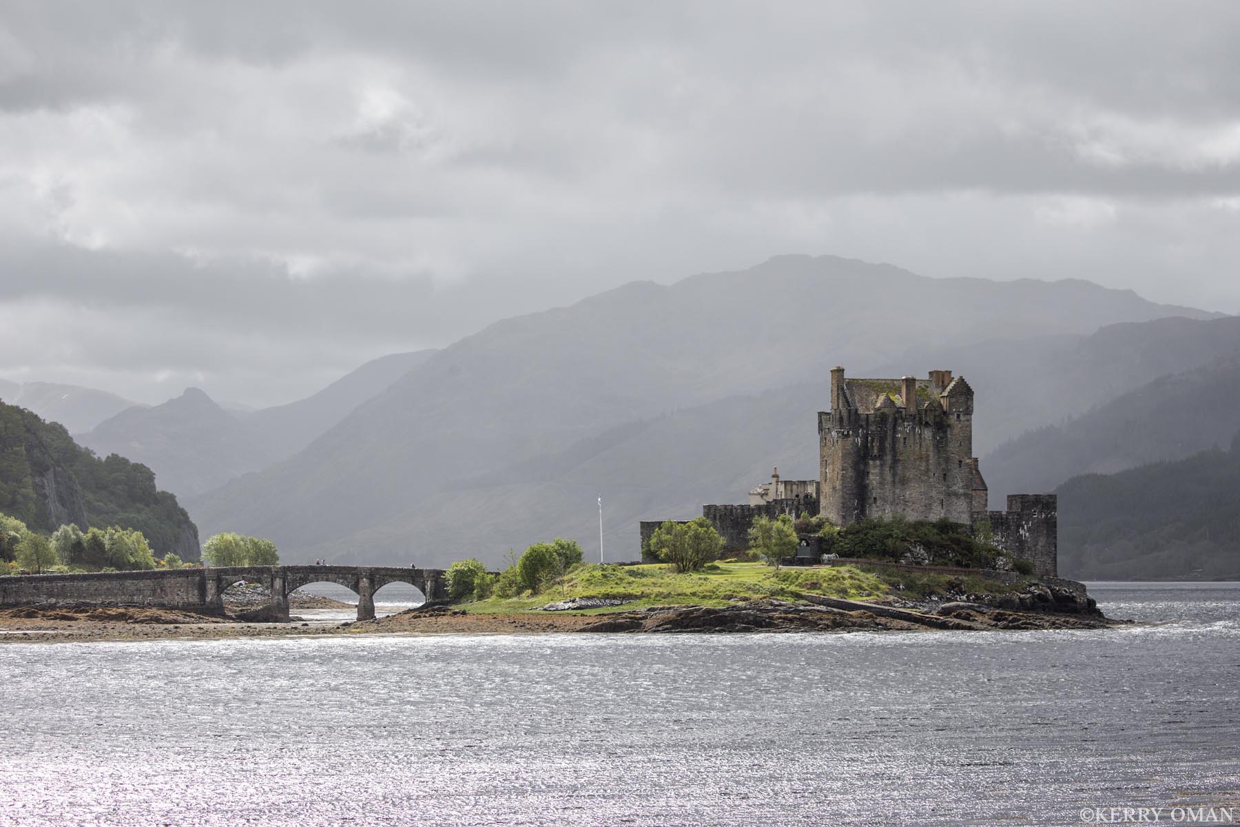 Sentinel of the Loch Eilean Donan Castle stands firm at the water’s edge, lit briefly by a break in the Highland sky. The stone bridge that...