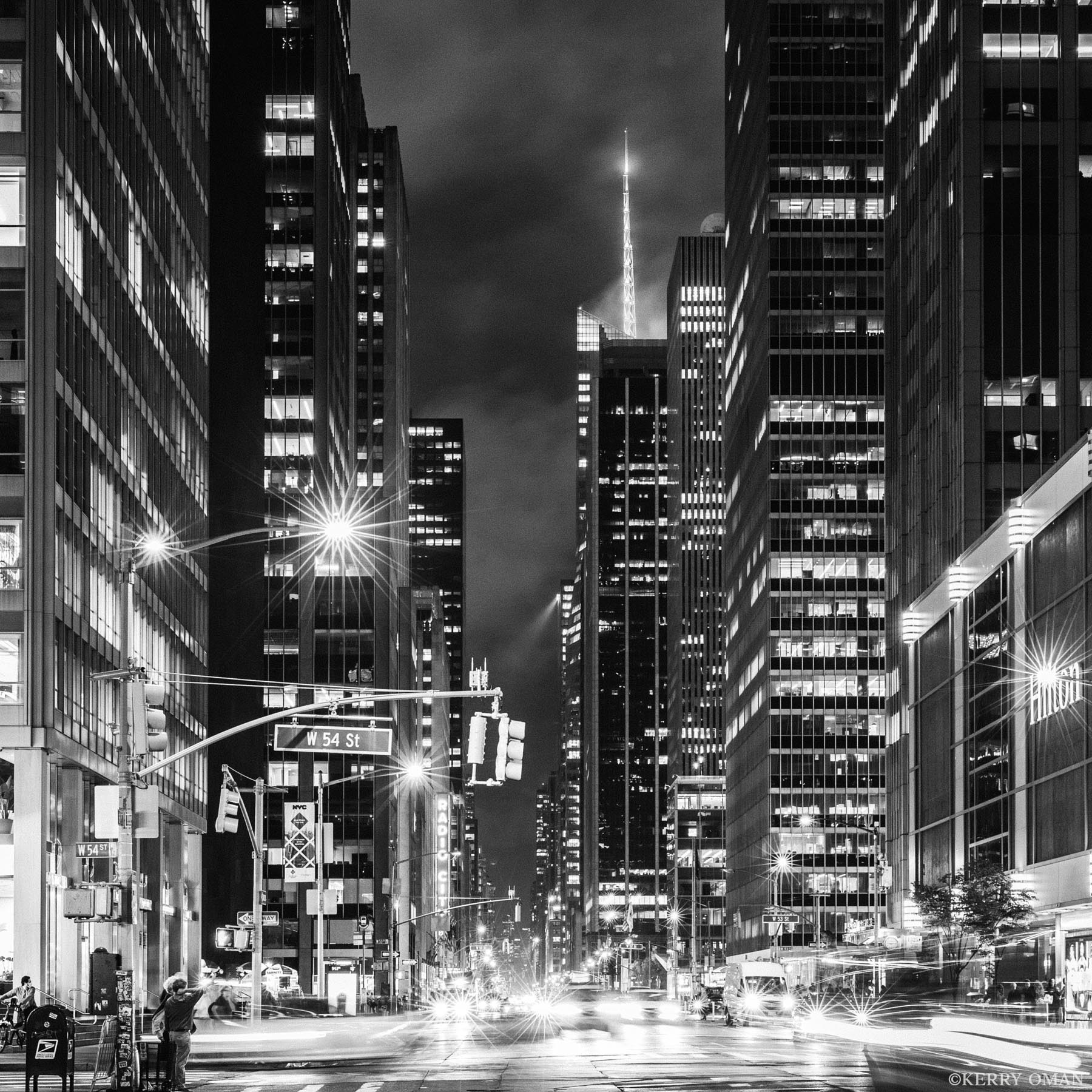 Midtown Lines Looking west along 54th Street in Midtown Manhattan, this black and white image captures the clean geometry and steady pulse...