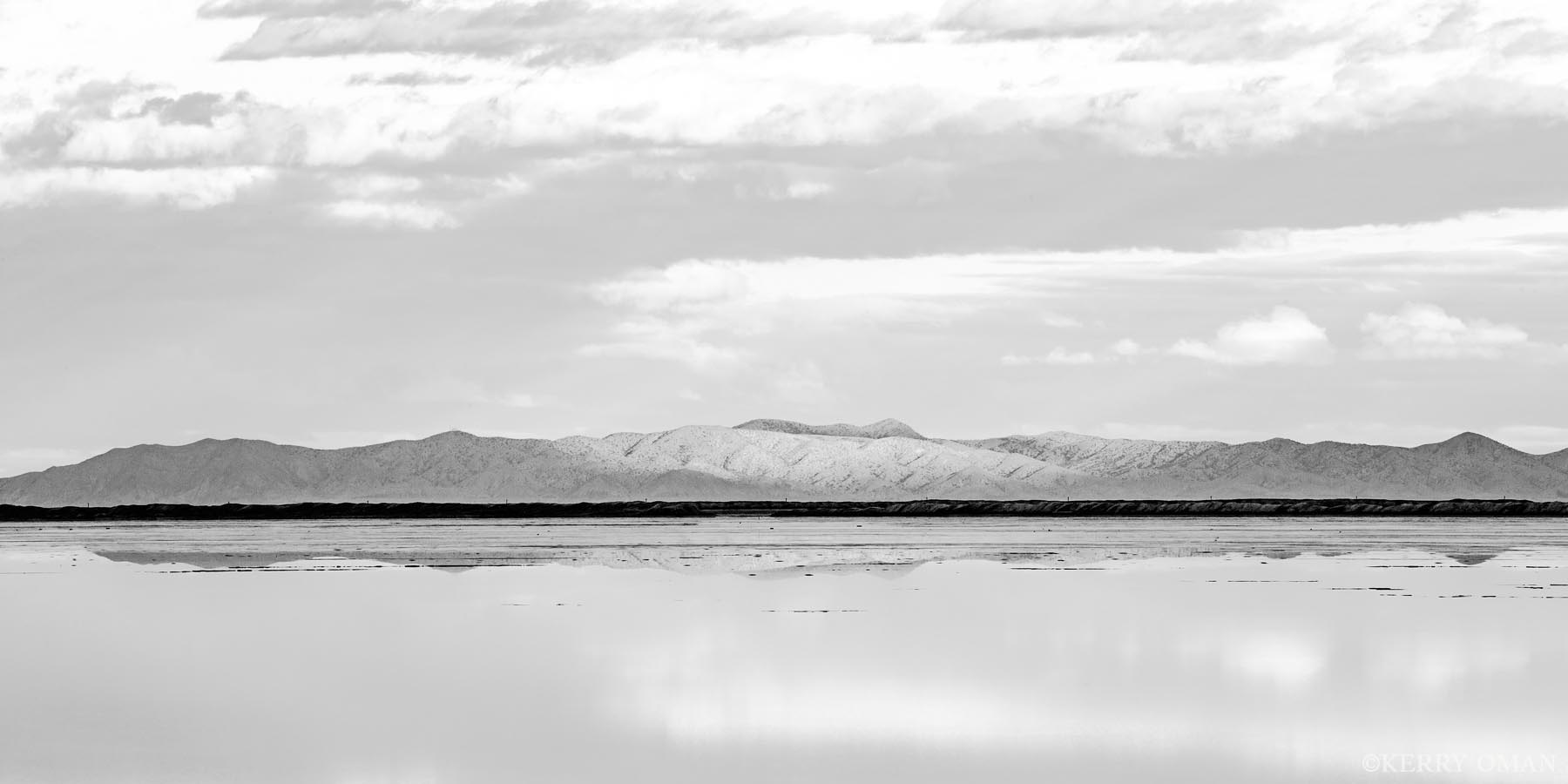 Reflected Silence A band of distant mountains is mirrored in the calm surface of Utah’s Salt Flats, creating a scene defined by balance and...